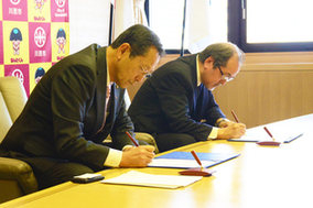 市長と宅建協会阪神北支部長が協定書に署名している写真