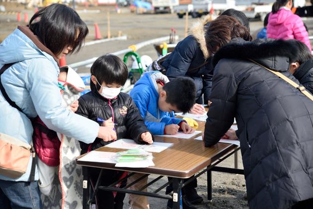 タイムカプセルに入れるカードにメッセージを書く参加者のみなさん