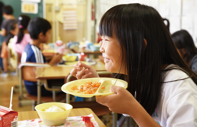 給食を食べる小学生の画像