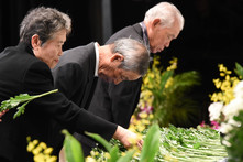 追悼の碑に献花する参加者の画像
