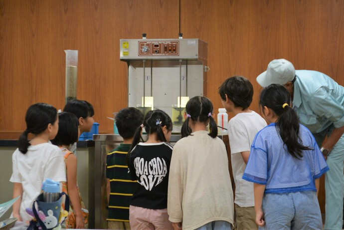 水をきれいにする実験を見学される様子