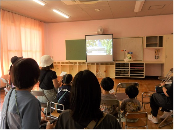 多田保育所「ありがとうの会」で映像を見る保護者・子どもたちや地域のかたがた